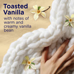 Close-up lifestyle image of hand touching a chunky knit blanket with text and vanilla flower graphics describing toasted vanilla scent