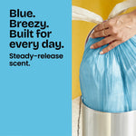 Hand tying a blue Glad drawstring bag inside a silver waste bin alongside text promoting steady-release scent and everyday use