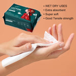 Closeup of hands using a white disposable cotton towel with the green product package and usage benefits listed nearby