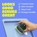 Hand scrubbing a tray with the Brite palm scrubber, blue background and text listing product benefits like powerful clean