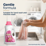 Scene of hands gently hand-washing a delicate pink garment with a Woolite Delicates bottle visible and 'Gentle formula' text.