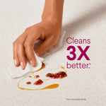 Hand using a wipe to clean a countertop with visible food residue and 'Cleans 3X better' promotional text