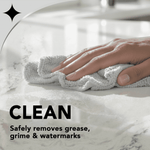 Hand wiping a marble-like countertop with a cloth, labeled clean and removes grease and watermarks