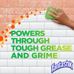 Hand using a green sponge to wipe tile with bold text 'Powers through tough grease and grime' and Fantastik logo