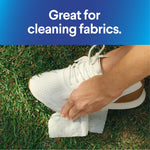 Hand wiping a white sneaker with a disinfecting wipe beneath text 'Great for cleaning fabrics.'