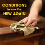 Close-up of a hand wiping a wooden surface with a cloth alongside text claiming it conditions to look like new again.