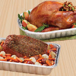Two aluminum roasting pans shown in use with a cooked roast and a roasted turkey on a wood-grain surface
