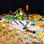 Table display of aluminum serving pans filled with turkey, sides, and pies on a fall-themed table setting