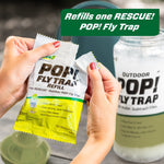 Hands holding a RESCUE! POP! Fly Trap refill packet with a blurred trap jar in the background and text overlay