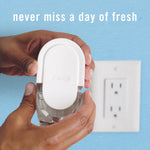Hands installing a Febreze plug-in unit into a wall outlet with text saying never miss a day of fresh