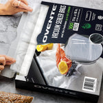 Hands pulling a precut vacuum bag from an Ovente product box, showing the box art and clear textured bags