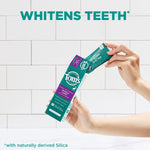 Hands holding a Tom’s of Maine Wintermint toothpaste box and pulling out the tube against white tiled background with 'whitens teeth' headline