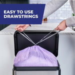 Hands pulling drawstrings to tie a purple Hefty trash bag inside a stainless kitchen trash can; overlay text about drawstrings
