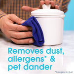 Close-up lifestyle shot of hands wiping a white ceramic jar with a blue cloth and overlay text about removing dust and pet dander