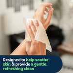 Hands using a Cottonelle wipe to gently cleanse skin in a neutral indoor setting