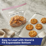 Hefty clear gallon zipper bag on marble counter holding chocolate chip cookies next to baking rack and parchment