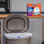 Kitchen scene showing an open trash can lined with a white Hefty bag and a Hefty box on the counter