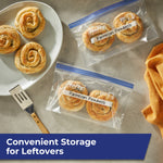 Two Hefty freezer bags on a counter labeled ‘Parmesan Pinwheels’ with baked pinwheels on a plate nearby.