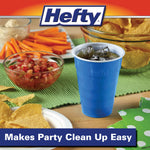 Blue Hefty cup filled with a drink shown on a party table with chips and dips behind