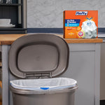 Kitchen scene with an open trash bin and a Hefty Ultra Strong box placed on the counter behind it.