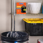 Hefty Strong orange box displayed on a metal shelf above a lined trash can and storage bin in a garage-style scene