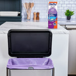 Open kitchen trash can lined with a purple Hefty trash bag and Hefty product box on the countertop behind it