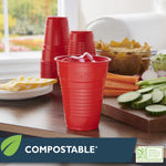Hefty red cup filled with ice on a table with stacked cups and snack spread in background