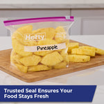 Hefty Slider quart bag filled with pineapple pieces on a cutting board, labeled 'Pineapple' on the bag