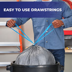 Hands pulling bright blue drawstrings closed on a gray Hefty Steelsak trash bag over a black trash can