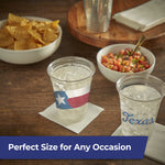 Two filled Hefty Texas-print clear cups on a wooden table with chips and salsa in bowls in the background.