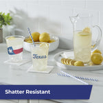 Styled kitchen scene with two Hefty clear cups printed ‘Texas’, a pitcher of lemonade and lemons on a tray.