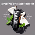 Hello epic whitening charcoal toothpaste tube pictured with coconut pieces, mint leaves and charcoal pieces on grey background