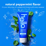 Hello superfresh peppermint toothpaste tube surrounded by mint leaves and artistic brush strokes on a bright blue background