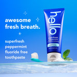 Hello superfresh peppermint toothpaste tube standing on a reflective surface with toothbrush and mint leaf accents