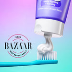 Purple Hello whipped toothpaste tube dispensing a swirl of paste onto a toothbrush, Harpers Bazaar badge visible