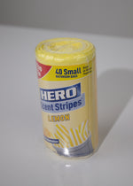 Angled view of a HERO Scent Stripes lemon-scented trash bag roll in clear wrap, label visible with brand and lemon artwork.