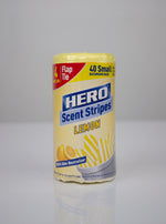 Studio-style image of a HERO Scent Stripes lemon roll standing upright, showing label text, lemon image and striped bag illustration.