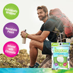 Outdoor lifestyle shot of a hiker sitting on a rock wearing a green coiled Bugables wristband, with product pouch and informational callouts.
