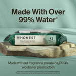 Honest flushable wipes pack displayed on a stone slab with large text stating made with over 99% water and product label visible.