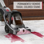 Hoover upright carpet cleaner removing a large red stain from a light carpet with headline text about removing tough colored stains.