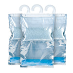 Three Humydry hanging moisture-absorber bags arranged side-by-side showing granules and collected liquid.