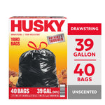 Front-facing Husky yard bag box showing a tied black drawstring trash bag over autumn leaves with bold HUSKY logo.