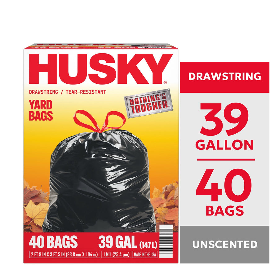 Front-facing Husky yard bag box showing a tied black drawstring trash bag over autumn leaves with bold HUSKY logo.