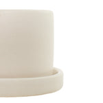 Close-up view of a semi-matte cream ceramic planter rim and matching saucer, neutral texture visible