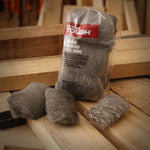 Hyper Tough clear-packaged steel wool pads displayed on a wooden workbench with loose pads in front