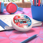 Ice Breakers Duo strawberry mint tin shown in a study-style scene with notebook, pens and headphones on a pink table