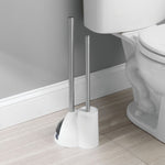 Compact white holder with two stainless-steel handles for a toilet brush and plunger on bathroom floor