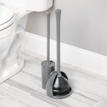 iDesign gray toilet plunger and brush set positioned on a bathroom floor next to a toilet bowl