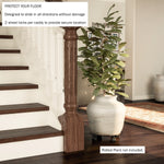 Indoor scene of a large ceramic planter on a black metal caster plant caddy near stairs