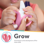 Infant holding a pink Nuby NanaNubs banana toothbrush while an adult guides it